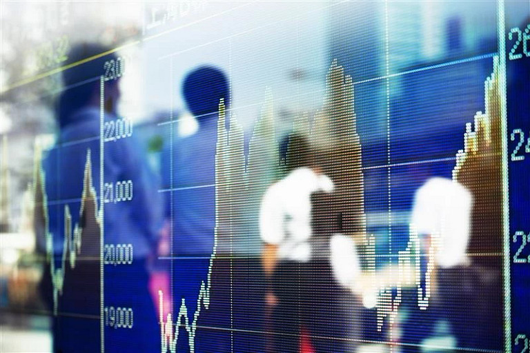 Stock market graph reflected over an out of focus image of people walking in the street wearing office attire