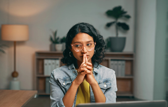 a person sitting at their desk looking thoughtful and concerned