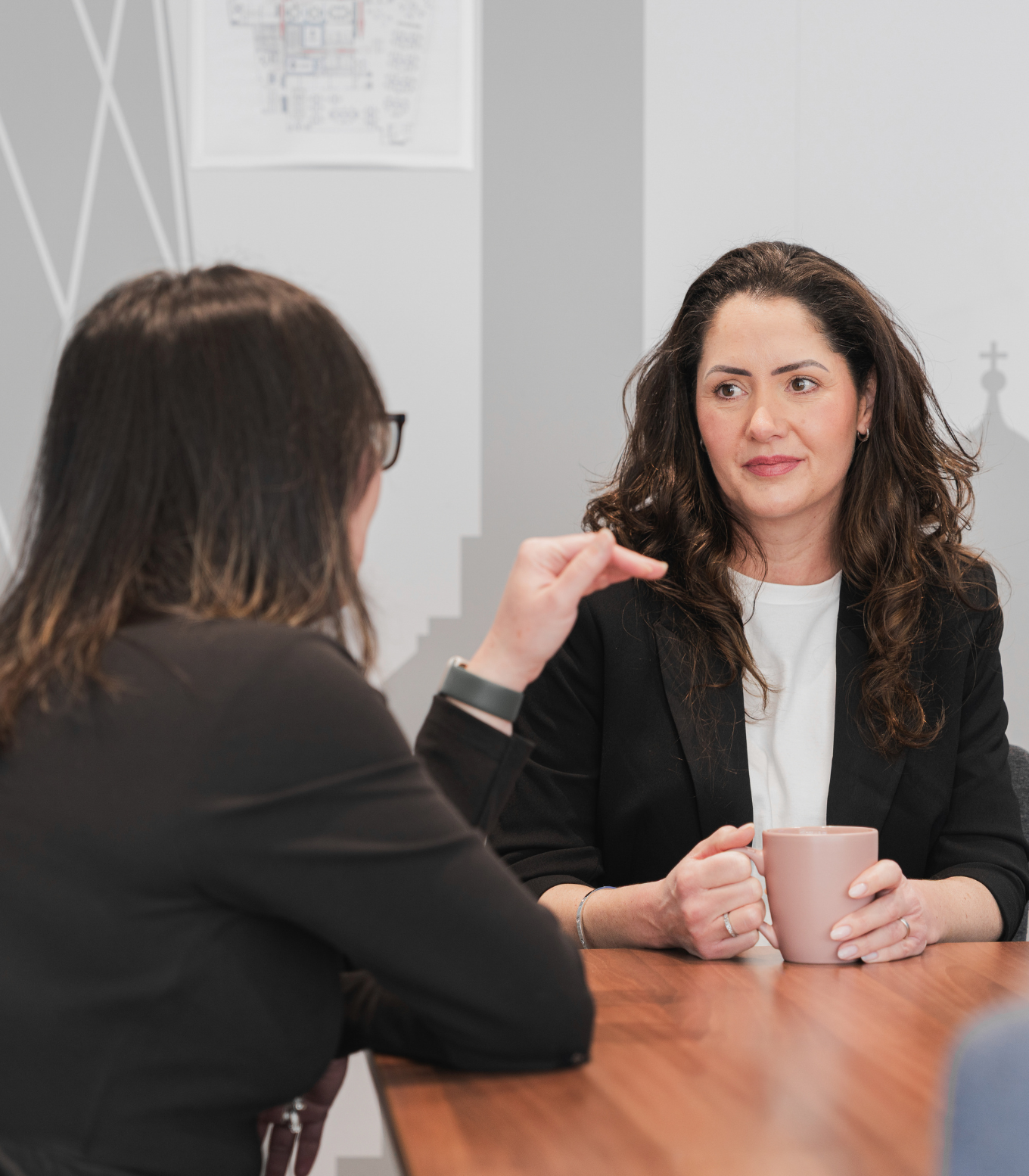 Two colleagues sat talking in a meeting room